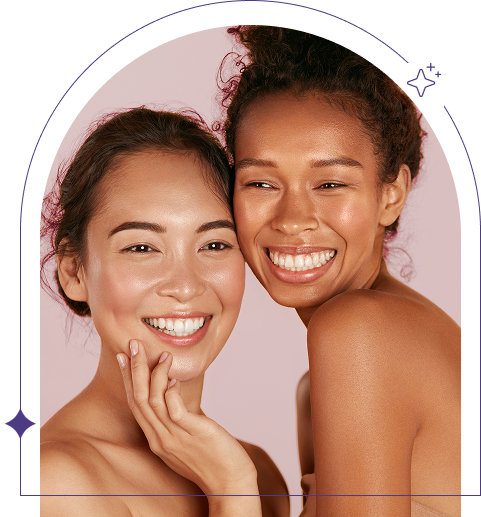 Two women with clear skin smiling against a pink background