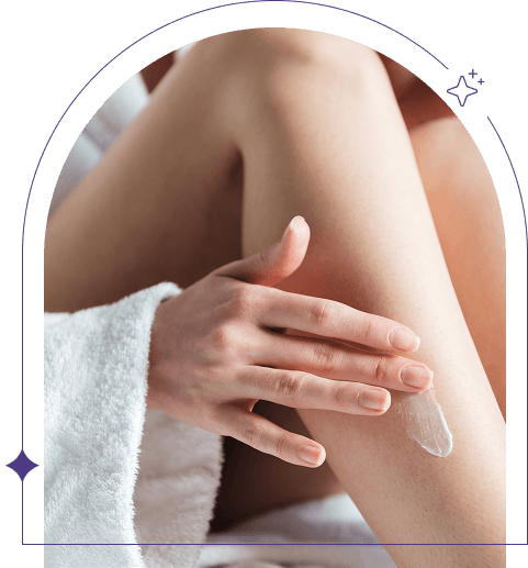 Woman gently applying body lotion to her leg